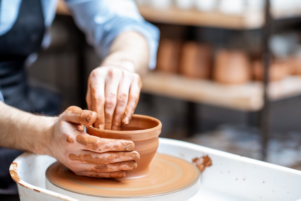 Making clay jug with pottery wheel